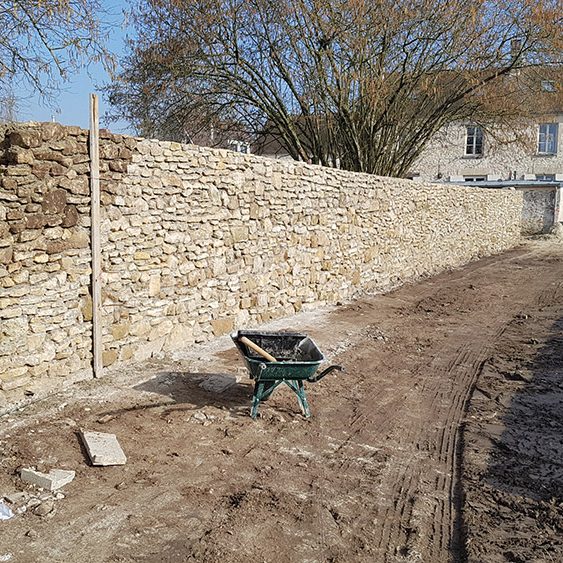 Construction d'un mur en pierre sèche de récupération , montage au mortier maigre